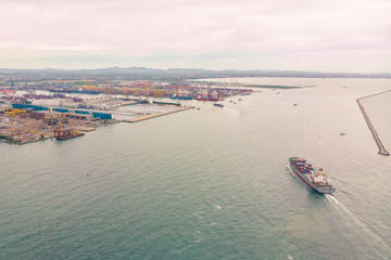 Obraz premium Aerial view of Small container ship at sea freight, Business International trade and Container logistics export-import harbor to the International port / Shipping Containers concept.