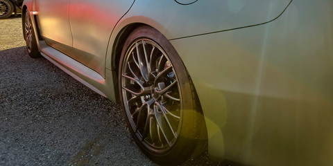 Polished silver car with black tire rim