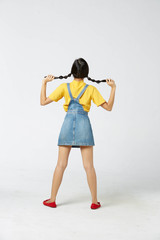 Isolate young tan Asian woman wearing yellow t-shirt, jeans dungarees and expressive facial on white background