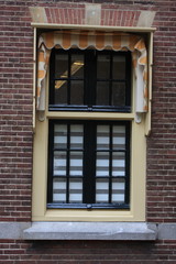 Fototapeta na wymiar window with Curtain in the Dutch Citz with red brick wall.
