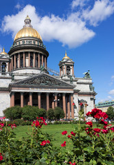 Fototapeta na wymiar St. Petersburg in the summer. Beautiful park with green lawns and flower beds with red roses near St. Isaac's Cathedral