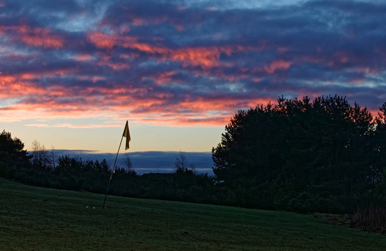 Red Sky, Cloudy Sunset Over Golf Course Green With Flag, Westhill, Aberdeenshire, Scotland