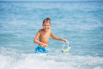 Fototapeta na wymiar Boy having fun on tropical beach on suuny day