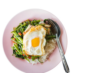 Fine Thai food with crispy pork and fried eggs in a plate on a white background.