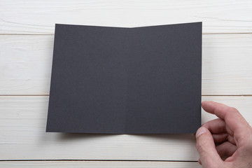 Mens hands holding empty black booklet