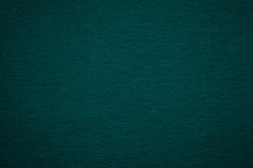 Texture of old dark green paper background, closeup. Structure of dense deep bluish cardboard.