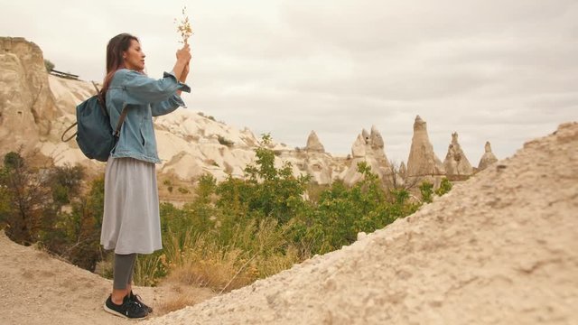 Young Mixed Race Tourist Girl Taking Pictures of Beautiful Mountain Rocks Using Mobile Phone in Cappadocia, Turkey. 4K Slowmotion.