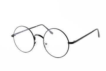 Round black-rimmed glasses are view from above. Hand holds glasses. Isolated on a light background. Turned left.