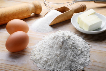 Baking ingredients on pastry board. Eggs, butter, sugar and flour