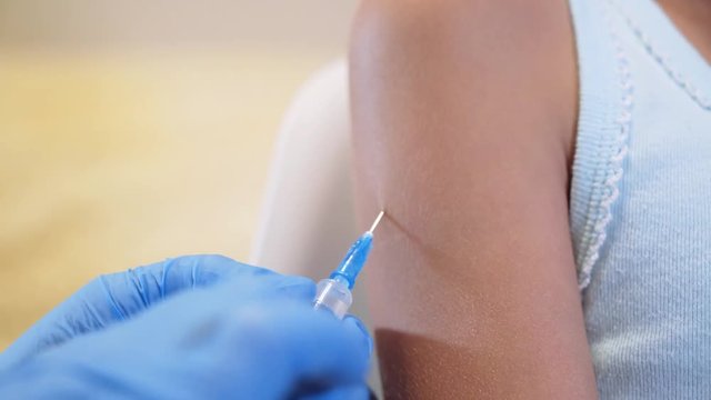 Shot of human hands making an injection with a syringe