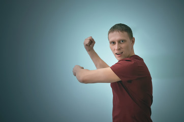 Angry man is swinging by copy space isolated on blue background.