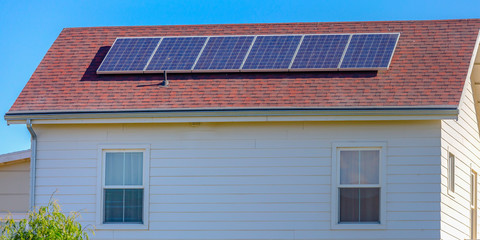Solar panels mounted on the red rooftop of a home