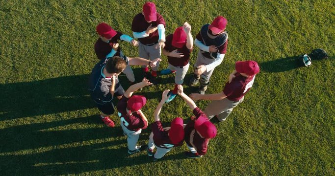 OVERHEAD CRANE kid boys huddling up with their coach before game. 4K UHD 60 FPS SLO MO