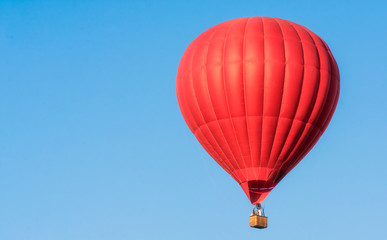 Obraz premium Red balloon in the sky. Aerostat. People in the basket. Fun. Summer entertainment. Romantic adventures.