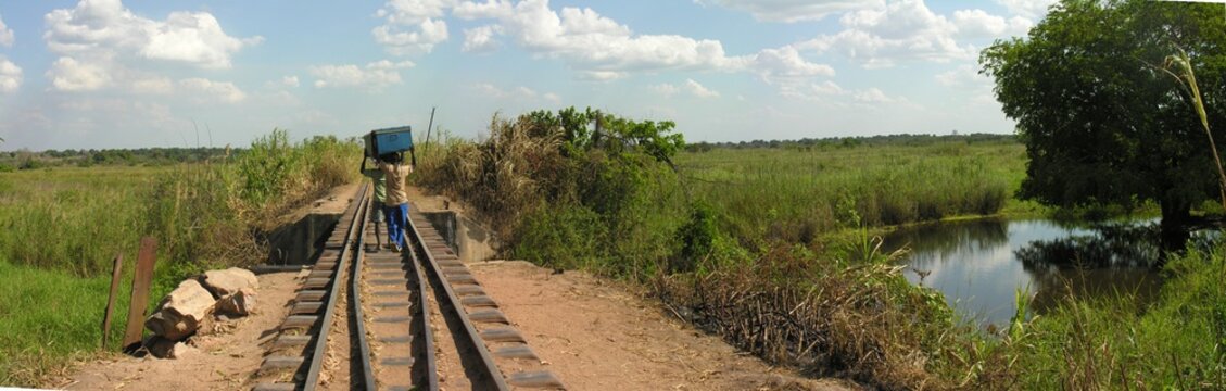 Carriers cross bridge along abandoned railroad, Katanga, Congo