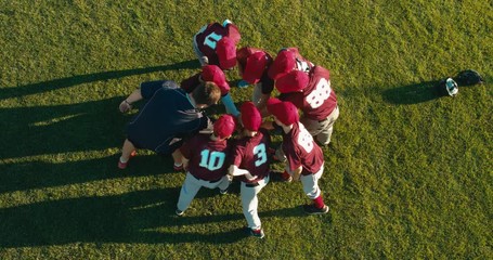 OVERHEAD CRANE kid boys huddling up with their coach before game. 4K UHD 60 FPS SLO MO