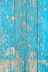 Close up of a old wooden door, teal blue paint peeling off; texture background