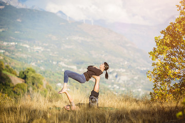 Fototapeta na wymiar Giovane coppia pratica acroyoga e yoga all'aperto in montagna al parco