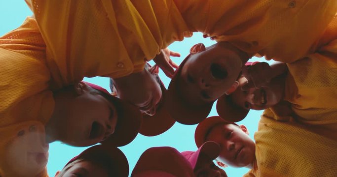 LOW ANGLE kid boys huddling up before game, captain inspires his team. 4K UHD 60 FPS SLO MO