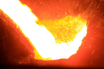 flowing molten iron in the iron works blast furnace taphole