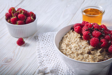 Oatmeal in a plate. Napkin. Nuts Berries. Honey