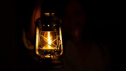 Somebody is holding a classic kerosene lamp during night (totally dark area) - Powered by Adobe