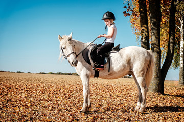 mädchen teitet auf weißen pony