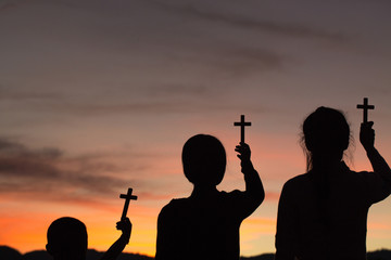 Three children worship God by holding christian Cross  with light sunset background, christian...