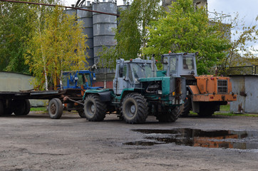 Fototapeta na wymiar Parking of old Soviet diesel bulldozers and tractors on large wheels in the territory of the automobile plant
