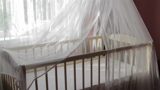 an empty crib for infants,in the room there is a new crib for babies, waiting for a baby, buying a new crib