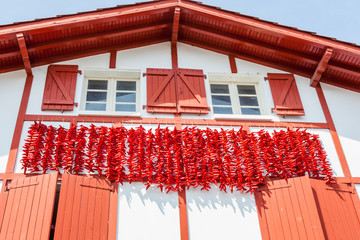 Cordes de piments d'Espelette séchant sur les façades des maisons en pays Basque
