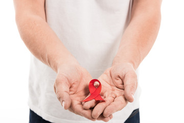 cropped shot of man in blank white t-shirt holding aids awareness red ribbon isolated on white