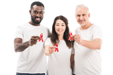 multiethnic group of people in blank white t-shirts holding aids awareness red ribbons and looking at camera isolated on white