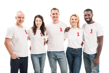 happy group of people in blank white t-shirts with aids awareness red ribbons looking at camera isolated on white