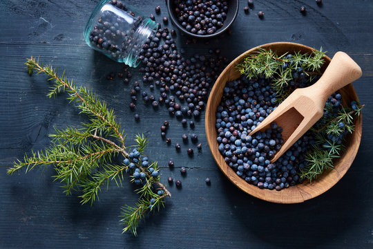 Fototapeta Wooden bowl with seeds of juniper.
