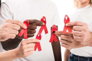 cropped shot of people in blank white t-shirts holding aids awareness red ribbons