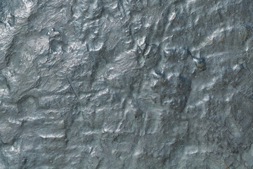 The surface of a large bronze plate with oxidation. On the surface of many different mounds and depressions, depressions. Lots of little dots. Bronze has a green tint. Background, texture, backdrop.