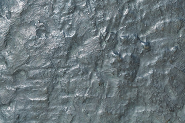 The surface of a large bronze plate with oxidation. On the surface of many different mounds and depressions, depressions. Lots of little dots. Bronze has a green tint. Background, texture, backdrop.