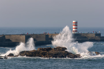 Fototapeta na wymiar Waves crash the rocks near Felgueiras lighthouse in Porto city, Portugal