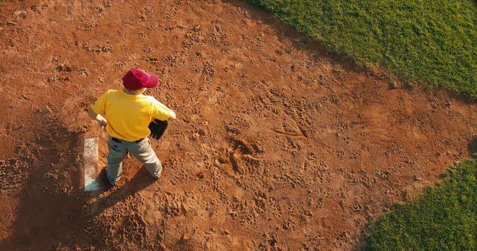 OVERHEAD CRANE Kid boy pitcher baseball player throws a ball from the pitcher's mound. 4K UHD 60 FPS SLO MO RAW