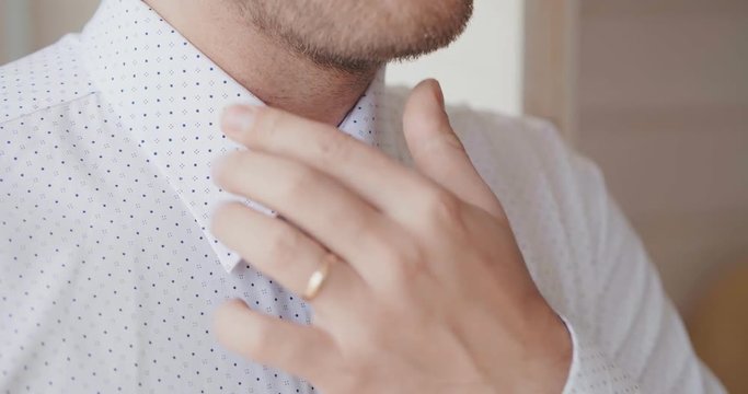 Close up of man dressing up ato go at work