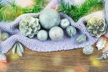 Fototapeta na wymiar Christmas composition shiny balls nuts cones branches cedar leaves silver on wooden dark background purple plaid Top view flat lay selective focus copy space