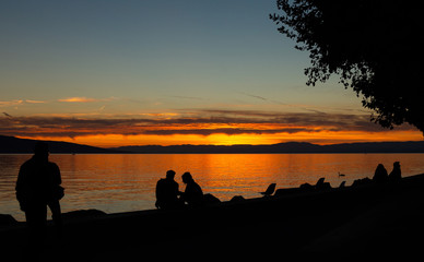 Naklejka na ściany i meble Sunset. People. Silhouette. Lake. Sky. Evening