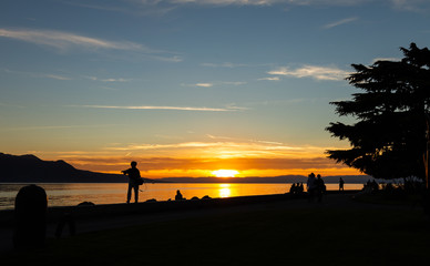 Fototapeta premium Sunset. Silhouette. People. Lake. Evening. Sky