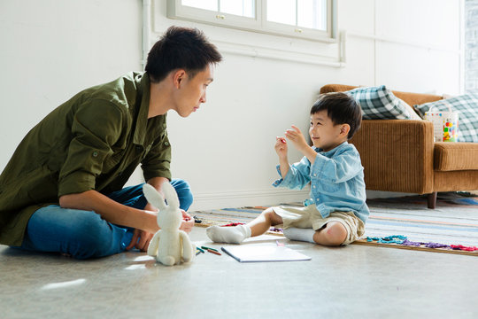 Father drawing with son at home