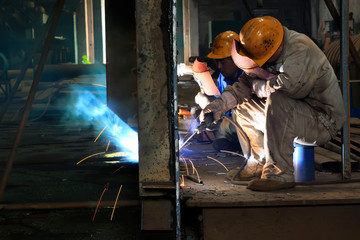 Worker welding parts in the production workshop