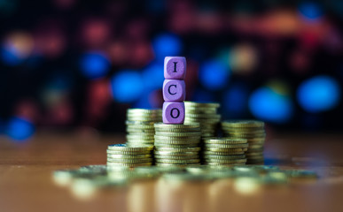 Colorful dice with text ICO (Initial coin offering) on stack coins. Business concept.
