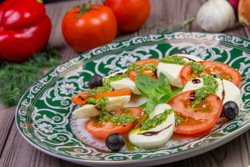 Fresh italian caprese salad with mozzarella and tomatoes on dark plate