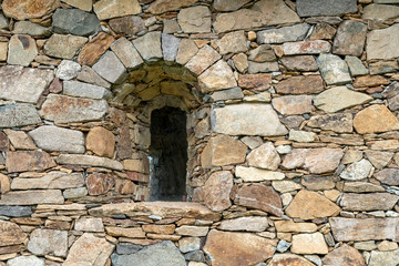 Fototapeta na wymiar Arched window in stone wall