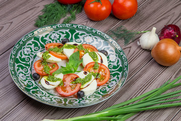 Fresh italian caprese salad with mozzarella and tomatoes on dark plate